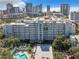 Stunning aerial view of condo building with downtown skyline, pool, and lush landscaping at 201 W Laurel St # 209, Tampa, FL 33602