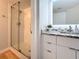 Well-lit bathroom with a glass-enclosed shower and modern vanity with marble countertops and white cabinetry at 201 W Laurel St # 209, Tampa, FL 33602