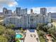 Elevated view of a condominium building with a swimming pool and skyline in the background at 201 W Laurel St # 209, Tampa, FL 33602