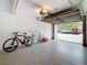 Epoxy floored garage featuring two bicycles, white walls, and an open door to the exterior at 201 W Laurel St # 209, Tampa, FL 33602