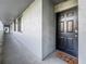 Hallway leading to unit entrance featuring a dark wood door, welcome mat, and textured wall at 201 W Laurel St # 209, Tampa, FL 33602