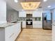 Contemporary kitchen featuring sleek white cabinetry, stainless steel appliances, marble countertops, and wood flooring at 201 W Laurel St # 209, Tampa, FL 33602