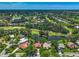 Picturesque aerial view of homes nestled within a community featuring a golf course and serene lake at 2081 Timucua Trl, Nokomis, FL 34275