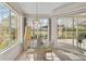 Sunlit breakfast nook with a glass table, seating for four, and views of the lanai and lake at 2081 Timucua Trl, Nokomis, FL 34275