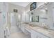 Bright main bathroom with double sinks, granite counters, tile floors, and large mirror over the vanity at 2081 Timucua Trl, Nokomis, FL 34275