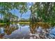 Picturesque view of a pond with lush landscaping and tranquil waters at 2081 Timucua Trl, Nokomis, FL 34275