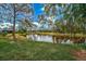 Beautiful view of a tranquil pond surrounded by lush trees and green lawn at 2081 Timucua Trl, Nokomis, FL 34275