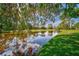 Picturesque view of a pond with lush landscaping and tranquil waters at 2081 Timucua Trl, Nokomis, FL 34275