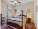 Comfortable bedroom featuring a four-poster bed, ceiling fan, and warm, inviting decor at 20909 Loggia Ct, Venice, FL 34293