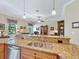 Kitchen with granite countertops, stainless steel appliances, and view into adjacent living room, creating an inviting and connected space at 20909 Loggia Ct, Venice, FL 34293