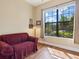 Cozy living room with hardwood floors, large window with view of lush tropical foliage and a comfortable sofa at 20909 Loggia Ct, Venice, FL 34293