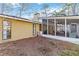 View of the home's exterior highlighting the spacious screened-in porch with an outdoor seating area at 2118 Wells Av, Sarasota, FL 34232