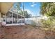 View of backyard with a sunroom, a white fence, and some landscaping at 2118 Wells Av, Sarasota, FL 34232