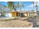 Single-story home featuring a spacious two-car garage and a welcoming entrance, nestled amidst mature trees at 2118 Wells Av, Sarasota, FL 34232