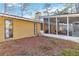 Exterior of a house with a sunroom, a chimney, windows, and a dry grassy yard at 2118 Wells Av, Sarasota, FL 34232