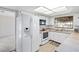 Kitchen with white cabinets, tile countertops, white appliances and view of the bedroom at 2118 Wells Av, Sarasota, FL 34232