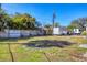 Large backyard featuring a wooden fence, green grass, and various vehicles parked nearby at 2202 21St W St, Bradenton, FL 34205