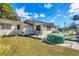 Backyard featuring a small deck with seating, an inflatable hot tub, and lush green grass at 2202 21St W St, Bradenton, FL 34205