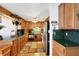 Traditional kitchen featuring wood cabinets, green tile countertops, and a decorative pot rack at 2202 21St W St, Bradenton, FL 34205