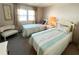 Bedroom featuring two twin beds, a nightstand, and natural lighting at 3236 Sumac Ter, Sarasota, FL 34237