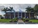 Exterior view of the brick clubhouse featuring columns, palm trees, and accessible parking at 3236 Sumac Ter, Sarasota, FL 34237