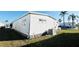 Side exterior of home with green grass, white siding, new AC unit and palm trees in the background at 3236 Sumac Ter, Sarasota, FL 34237