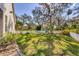 Green backyard with lush lawn and mature trees, enclosed by white picket fence at 3301 River Woods Dr, Parrish, FL 34219