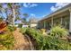 Lush backyard with a gravel path, manicured shrubbery and a screened-in porch at 3301 River Woods Dr, Parrish, FL 34219