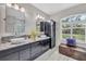 Well-lit bathroom with double sinks, granite counters, modern cabinets, and stylish décor at 3301 River Woods Dr, Parrish, FL 34219