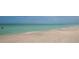 Scenic beach view of turquoise water gently lapping onto a shell-strewn sandy shore at 344 Monroe Dr, Sarasota, FL 34236