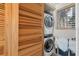 Functional laundry area with a stacked washer and dryer and slatted wood folding doors at 344 Monroe Dr, Sarasota, FL 34236