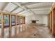 Open living room features exposed beams, a minimalist fireplace, and travertine flooring at 344 Monroe Dr, Sarasota, FL 34236