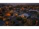 Stunning aerial view of waterfront homes and city skyline at night, showcasing prime real estate and illuminated pool at 355 W Royal Flamingo Dr, Sarasota, FL 34236