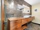 Modern bathroom featuring unique lighting fixtures, a floating vanity, and a stone accent wall at 355 W Royal Flamingo Dr, Sarasota, FL 34236