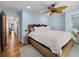 Bright bedroom with blue walls, a ceiling fan, a woven bed frame, and wood floors at 355 W Royal Flamingo Dr, Sarasota, FL 34236