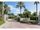 Grand Bird Key entrance with lush landscaping, a water feature, and stately palm trees on a sunny day at 355 W Royal Flamingo Dr, Sarasota, FL 34236