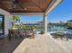 Covered outdoor dining area with travertine tile, a wood ceiling, and a view of the canal at 355 W Royal Flamingo Dr, Sarasota, FL 34236