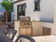 An outdoor kitchen with a stainless steel grill is adjacent to an outdoor dining area at 355 W Royal Flamingo Dr, Sarasota, FL 34236