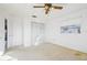 This bedroom features neutral carpet, a ceiling fan, natural light, and a double door closet at 4119 Royal Palm Dr, Bradenton, FL 34210