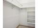 Empty closet features built-in shelving and a hanging rod at 4119 Royal Palm Dr, Bradenton, FL 34210