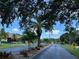 Neighborhood street featuring lush landscaping, mature trees, and a 15 mph speed limit sign at 4197 66Th Street W Cir, Bradenton, FL 34209