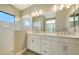 Well-lit bathroom with dual vanity, white cabinets, and a glass-enclosed shower at 421 Potenza Loop, Nokomis, FL 34275