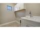 Laundry room with white cabinets, a sink and faucet, and tile flooring at 421 Potenza Loop, Nokomis, FL 34275