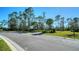 A street view of a typical tree-lined neighborhood, with a sidewalk and well maintained landscaping at 421 Potenza Loop, Nokomis, FL 34275