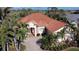 Aerial view of a beautiful single-story home featuring lush landscaping and a red tile roof at 4245 Corso Venetia Blvd, Venice, FL 34293