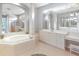 Bathroom featuring soaking tub with tile surround, large vanity area, and natural light at 4245 Corso Venetia Blvd, Venice, FL 34293