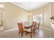 Cozy dining room featuring a glass-top table with seating for eight under a chandelier at 4245 Corso Venetia Blvd, Venice, FL 34293