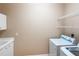 Bright laundry room offers upper cabinets, wire shelving, laundry sink and updated washer/dryer set at 4245 Corso Venetia Blvd, Venice, FL 34293