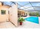 Inviting screened pool area with an outdoor shower, lush landscaping, and comfortable patio seating at 4245 Corso Venetia Blvd, Venice, FL 34293