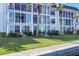 Waterfront condo building with large windows, lush landscaping, and private dock access on a sunny day at 4310 Falmouth Dr # 102, Longboat Key, FL 34228